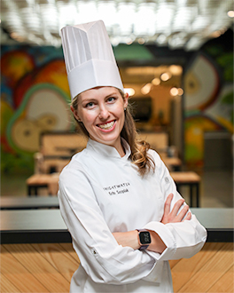 Woman Smiling wearing chef coat and smiling