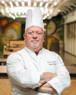 Man smiling wearing chef coat and hat